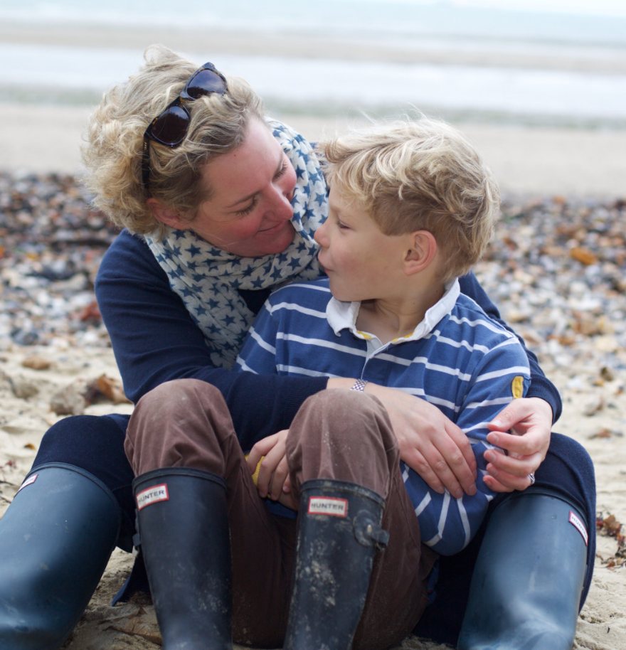 Frankie Gray sharing a cuddle with a young boy on the beach